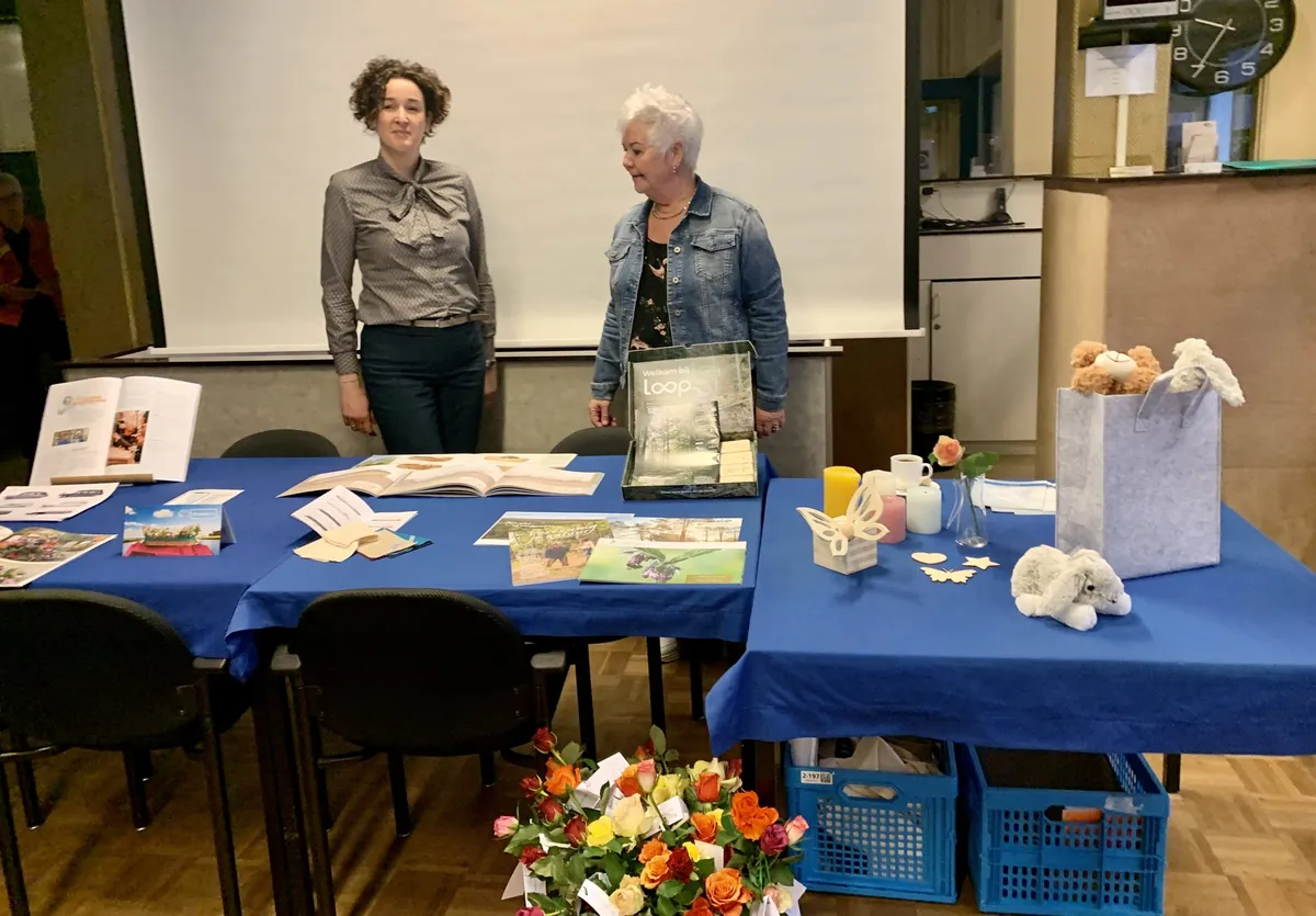 Els en Annemarie bij hun tafel met boeken, kaarten, kaarsen en troostknuffels