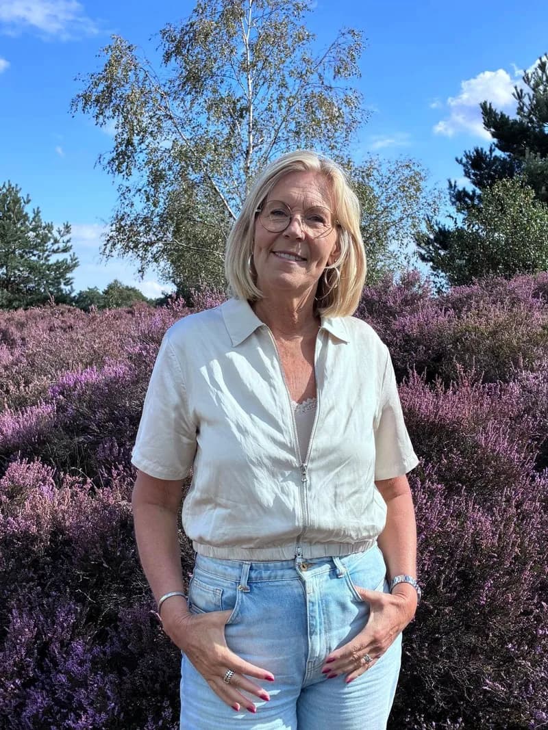 Portret van Ieke Kleijwegt in een veld met bloeiende heide