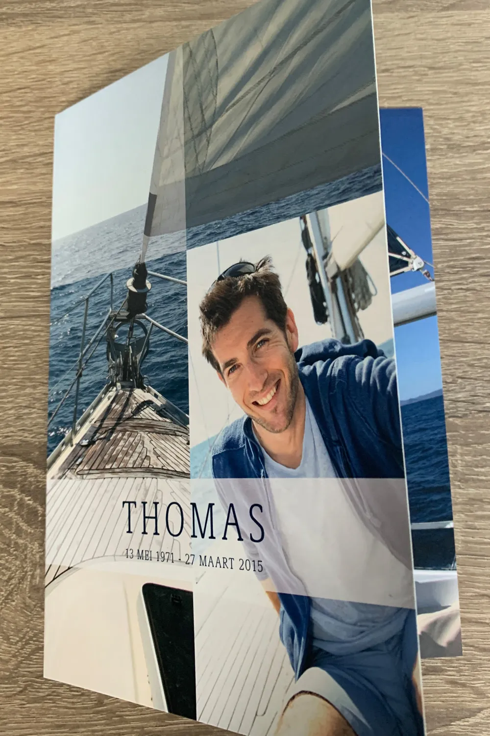 Rouwkaart met een foto van een zeiltocht op de voorkant