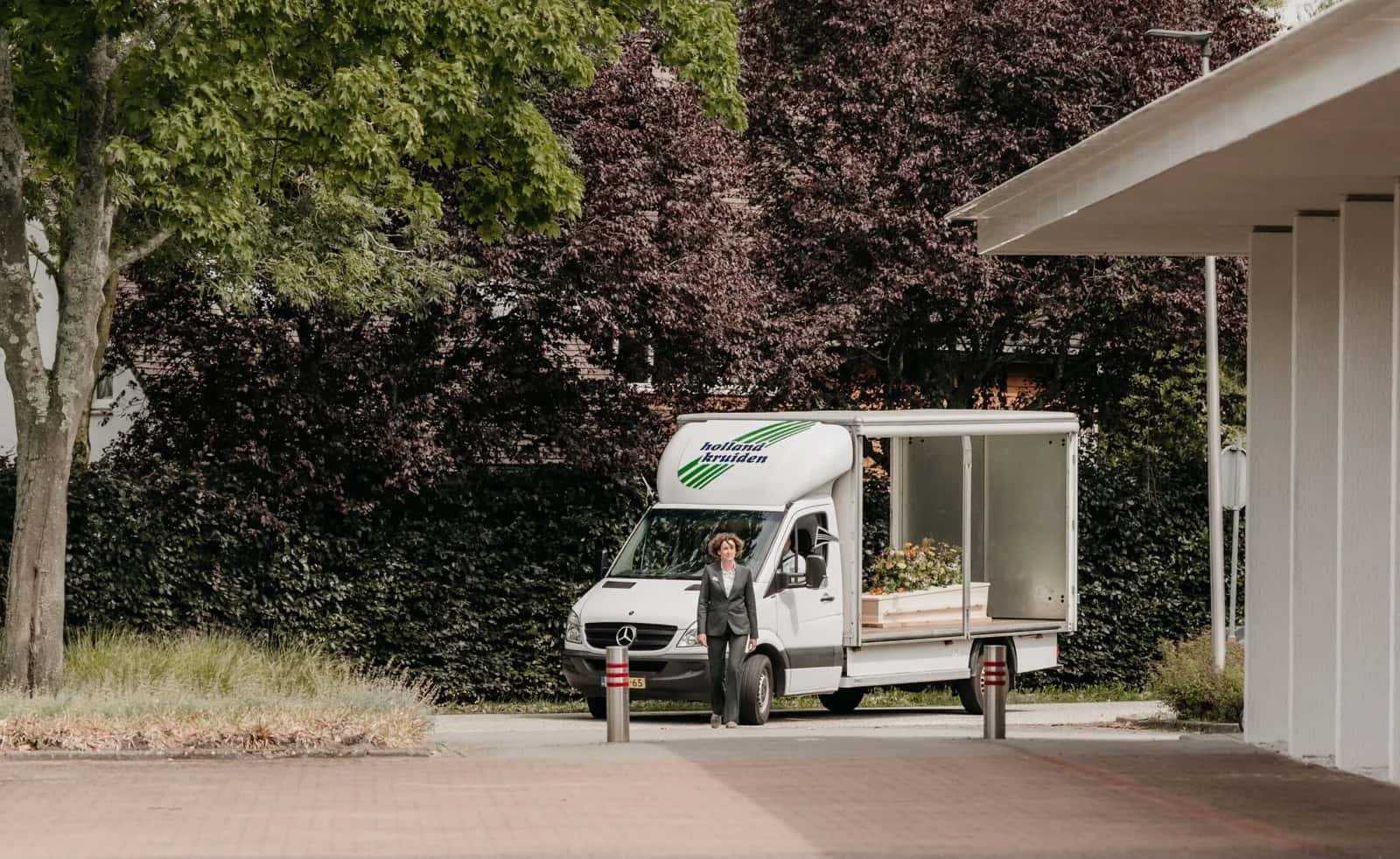 De vrachtwagen van het familiebedrijf onder de bomen