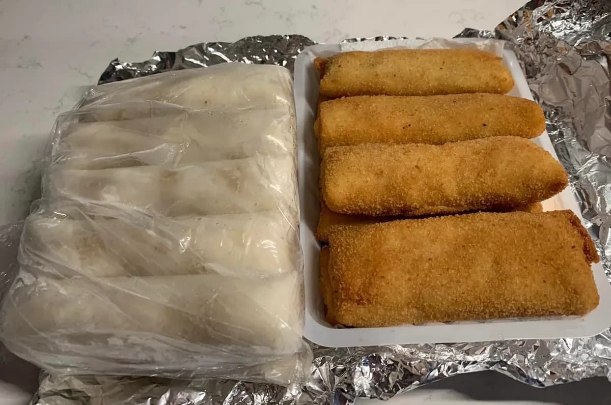 Twee schalen met Indonesische hapjes: lemper in folie en gefrituurde risolles